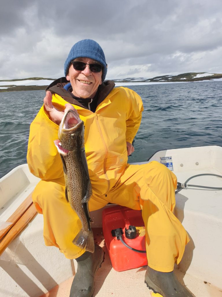 Tor med dagens fangst i gul regnjakke, Lofoten